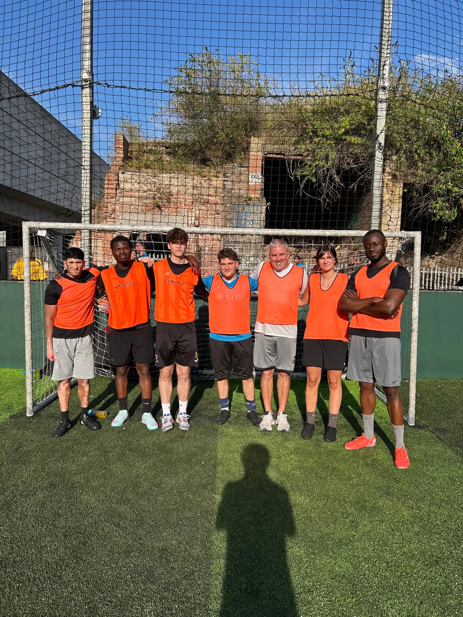 One of the Adobe tournament teams lined up in orange bibs in front of the goal before kick-off.